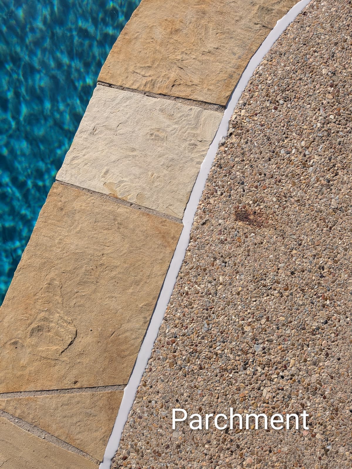 Sika Parchment pool mastic sealant color example on flagstone coping with exposed aggregate deck — smooth finish