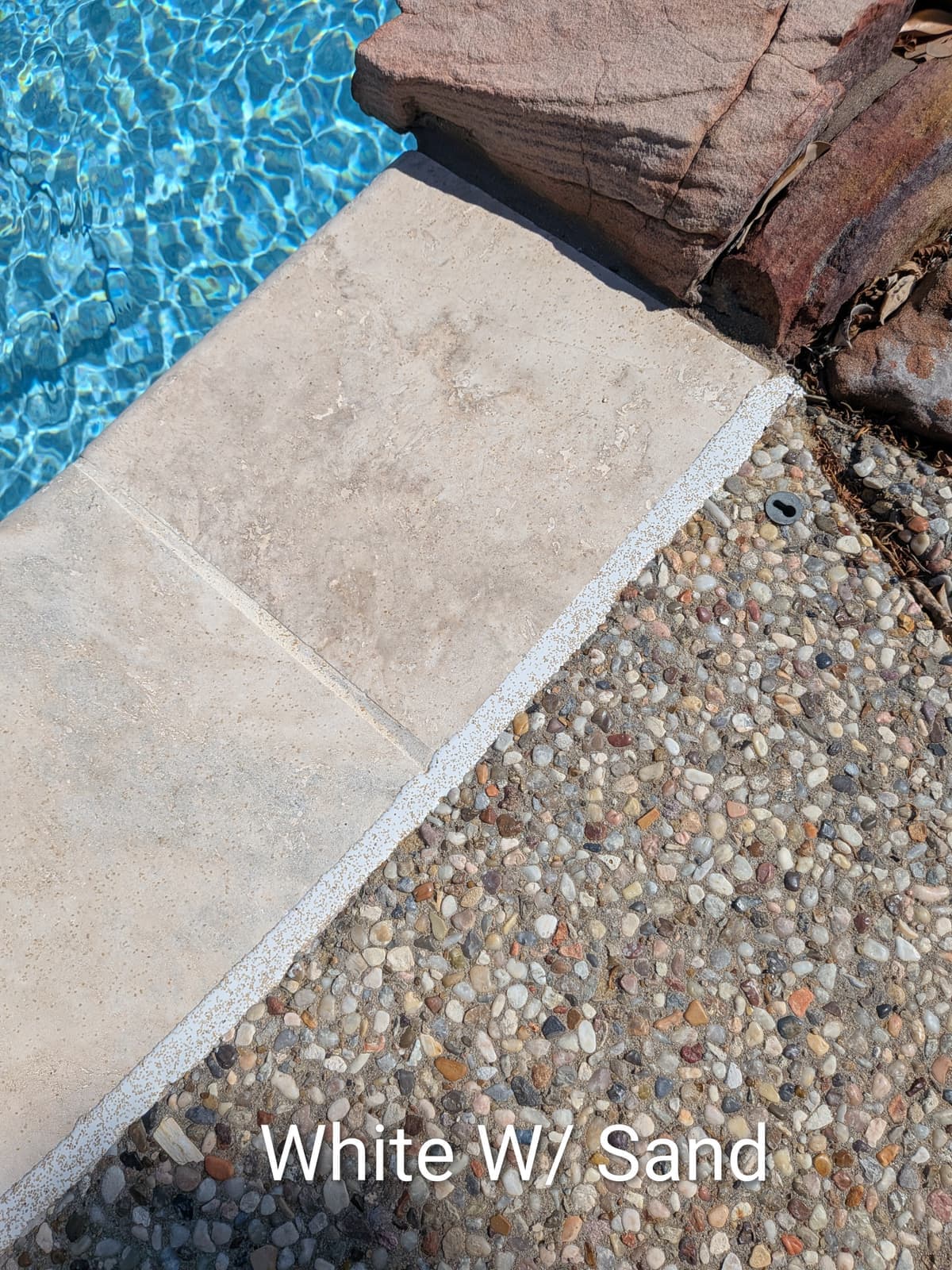 Sika White with Sand pool mastic sealant color example on travertine coping with exposed aggregate deck — textured sand finish